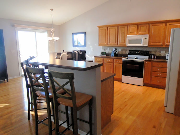 136 Lake Lida Lane Rochelle, IL 61068 - Photo 3 of 19 a kitchen with stainless steel appliances granite countertop a stove a sink a microwave and a refrigerator