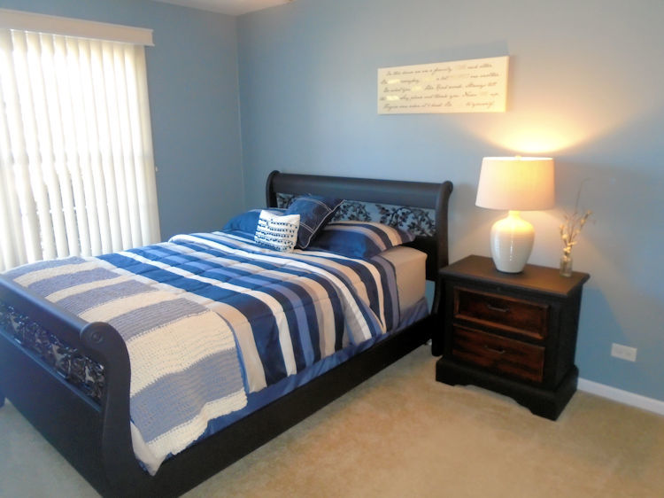 136 Lake Lida Lane Rochelle, IL 61068 - Photo 9 of 19 a bedroom with a bed and a lamp