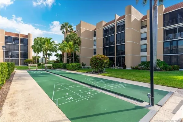a view of a backyard with potted plants and large trees