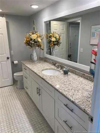 a bathroom with a granite countertop sink and a mirror