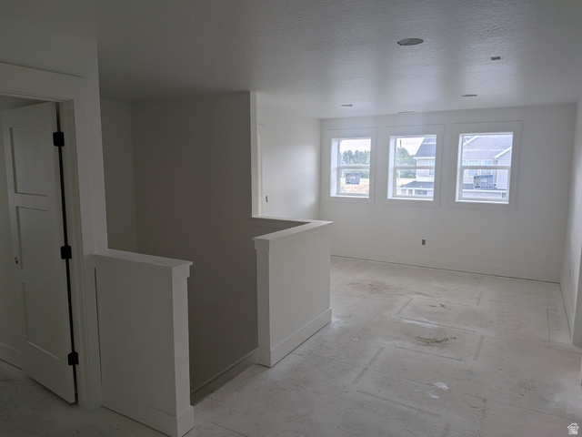 2771 West Aurora Avenue Mapleton, UT 84664 - Photo 21 of 39 Open loft space featuring three large windows, recessed ceiling lighting, a contemporary paneled interior door, and a painted half-wall railing