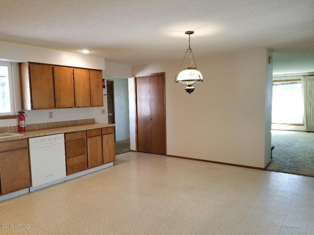 804 Bittner Road Yakima, WA 98901 - Photo 5 of 18 a kitchen with kitchen island granite countertop a stove a sink a refrigerator and white cabinets with wooden floor