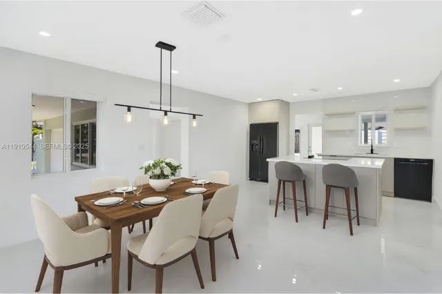 a view of a dining room and livingroom with furniture wooden floor a chandelier