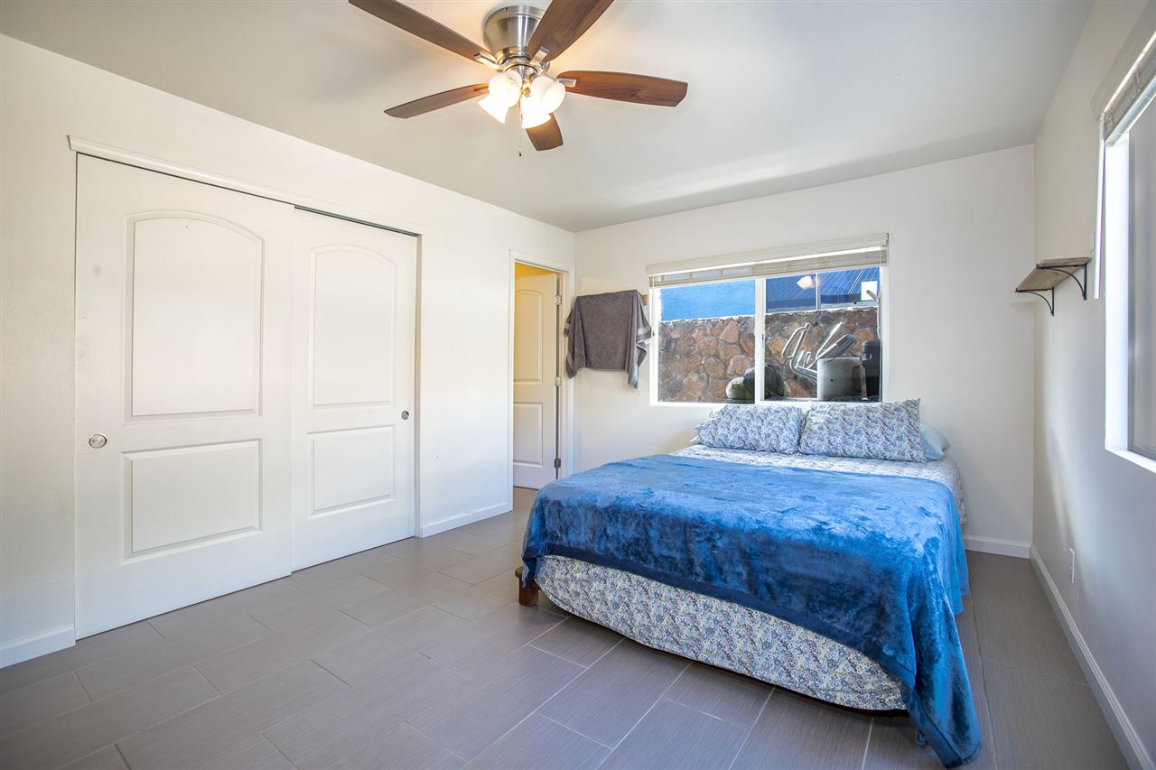 98 East Welakahao Road Kihei, HI 96753 - Photo 15 of 26 a bedroom with a bed and a chandelier