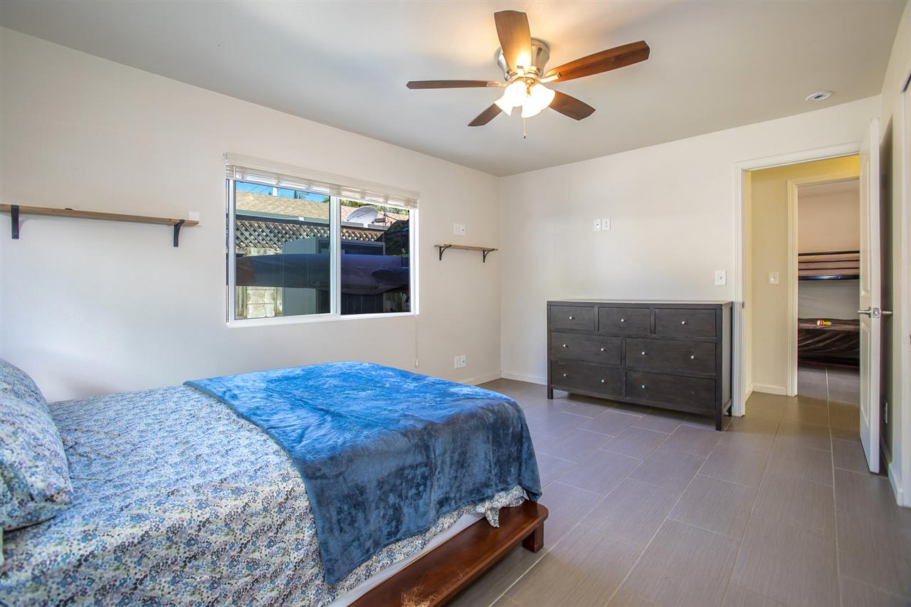 98 East Welakahao Road Kihei, HI 96753 - Photo 17 of 26 a bedroom with a bed and a chandelier