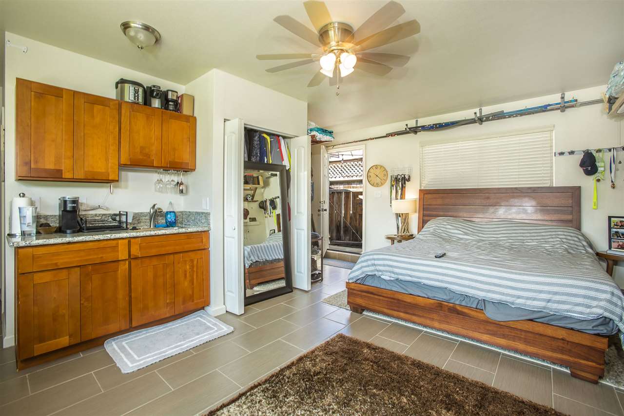98 East Welakahao Road Kihei, HI 96753 - Photo 20 of 26 a spacious bedroom with a bed and a chandelier