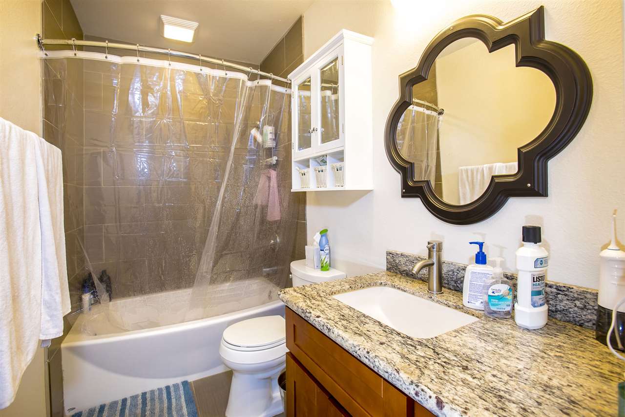 98 East Welakahao Road Kihei, HI 96753 - Photo 22 of 26 a bathroom with a granite countertop sink mirror toilet and bathtub