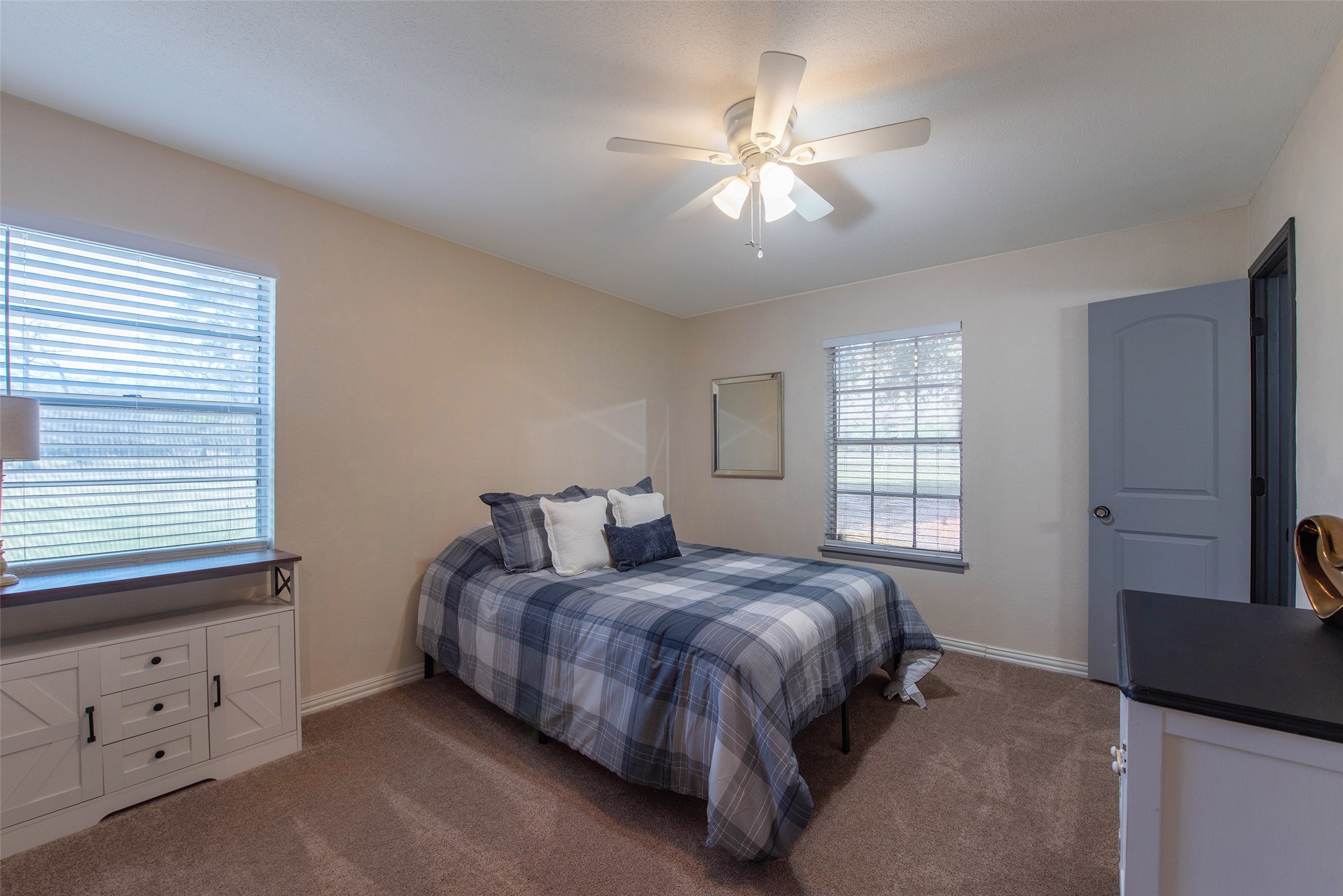 12998 Rocky Road Conroe, TX 77306 - Photo 30 of 50 a spacious bedroom with a bed and a chandelier