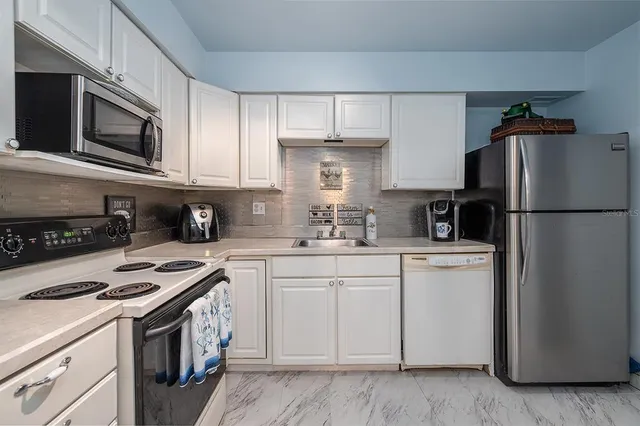 a kitchen with cabinets stainless steel appliances and a counter space