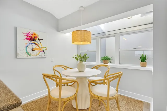 a dining room with furniture and painting on the wall