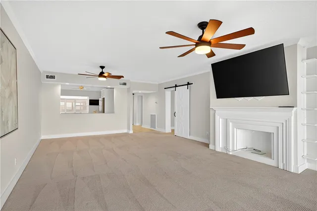 a view of a livingroom with a fireplace a ceiling fan and a window