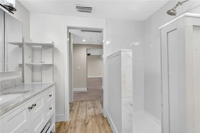 a bathroom with a sink vanity and a mirror