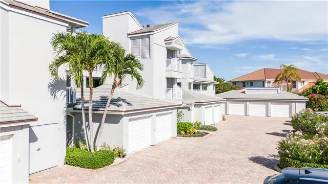 a front view of a house with a garden and trees