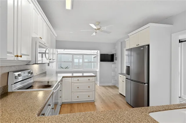 a kitchen with stainless steel appliances granite countertop a refrigerator stove and sink