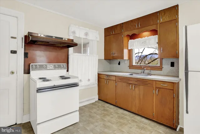 a view of a kitchen with a sink and a refrigerator