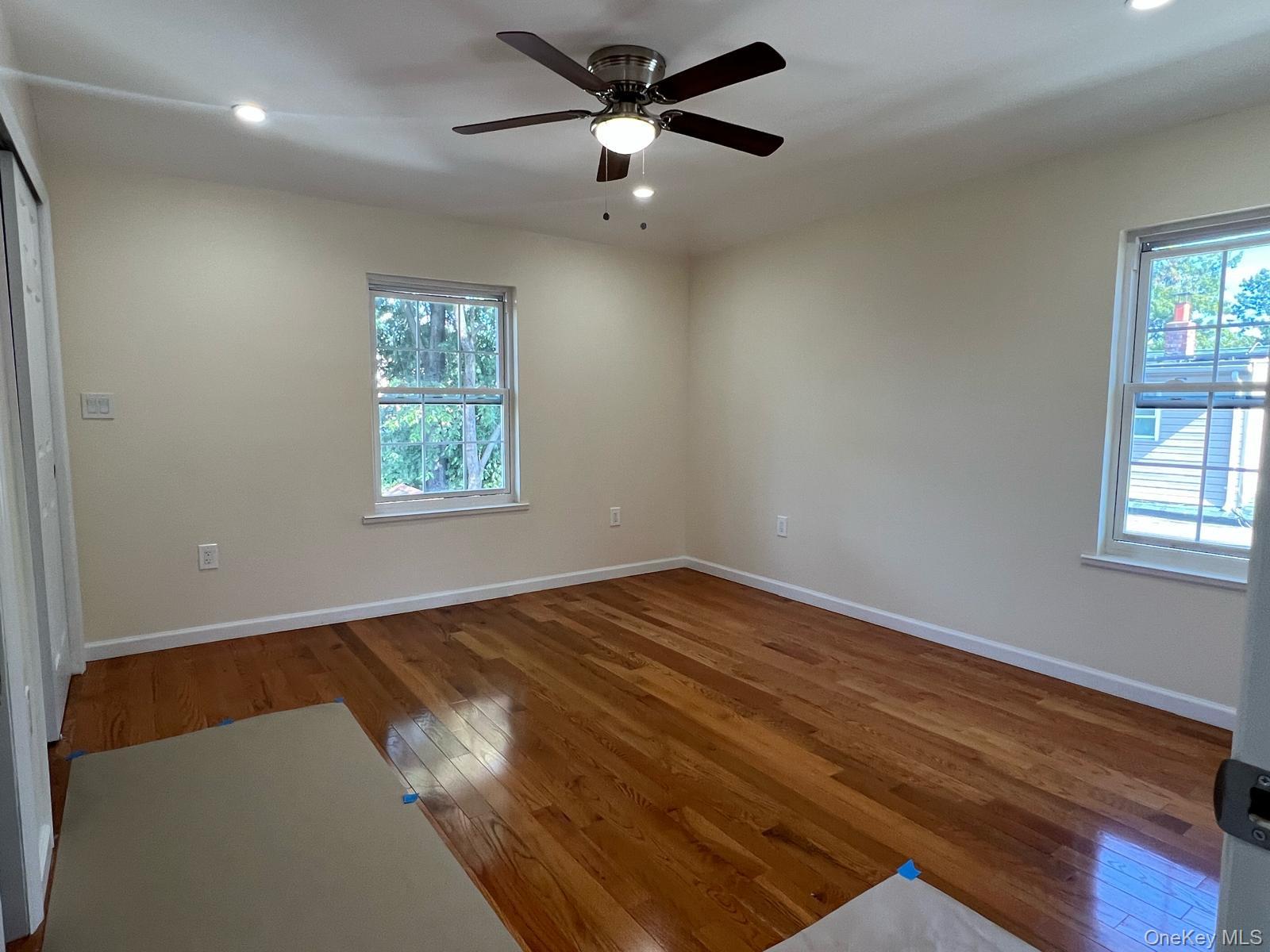 153-33 119th Road Queens, NY 11434 - Photo 9 of 9 a view of empty room with wooden floor and fan
