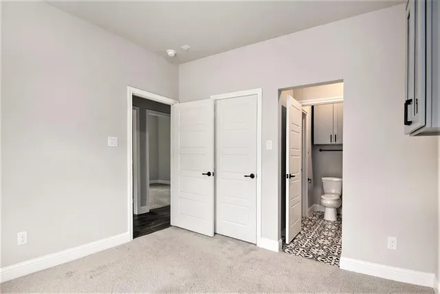 a bathroom with a granite countertop sink a toilet and a mirror