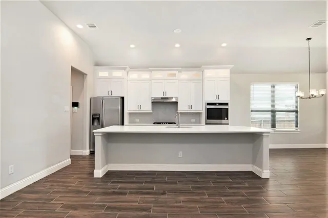 a view of kitchen with stainless steel appliances refrigerator sink and cabinets