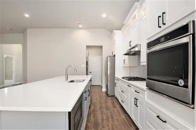 a kitchen with stainless steel appliances a stove microwave and cabinets