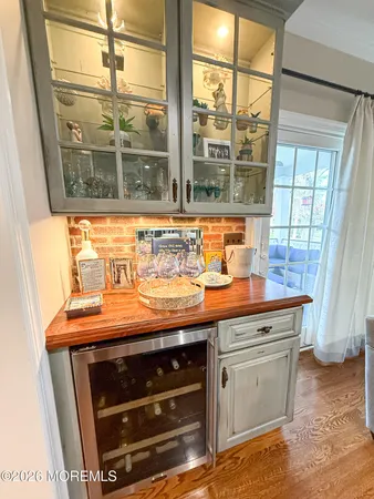 a kitchen with granite countertop a stove a refrigerator a sink a dining table and chairs with wooden floor