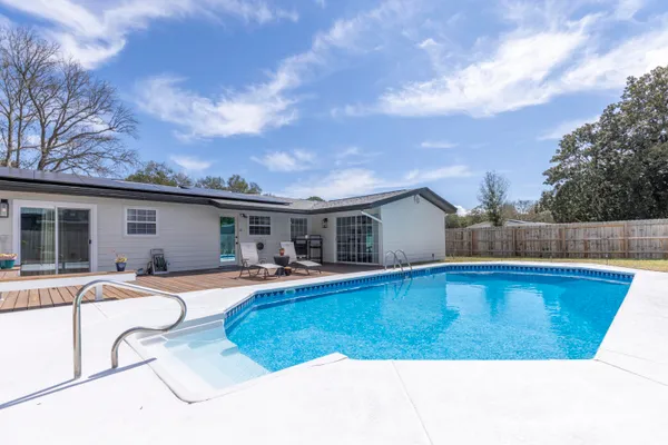 a view of a house with pool and chairs