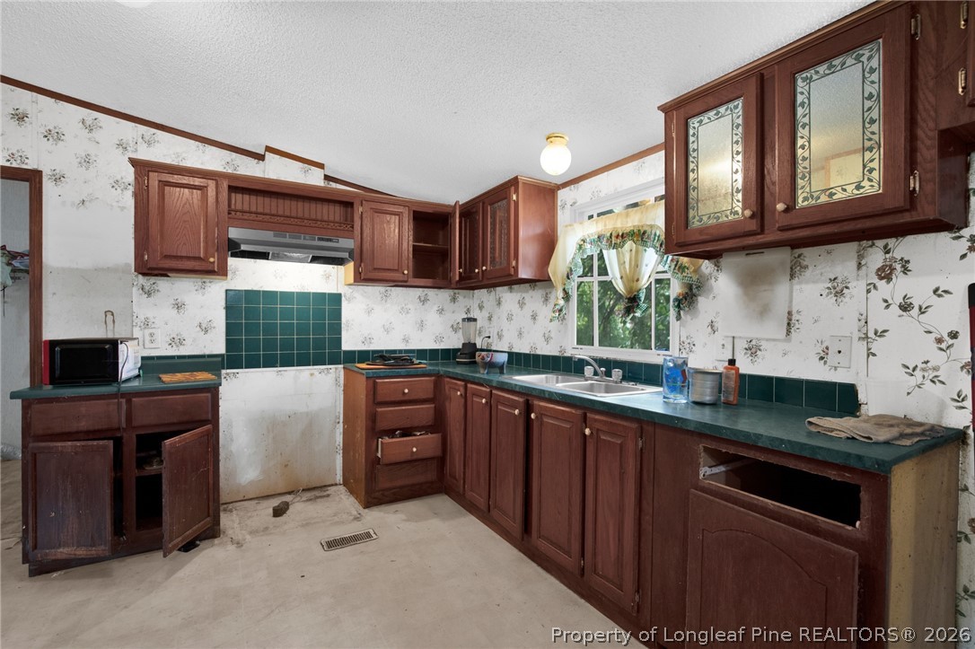 4705 Hickory Ridge Road Parkton, NC 28371 - Photo 15 of 37 a kitchen with stainless steel appliances granite countertop a stove sink microwave and cabinets