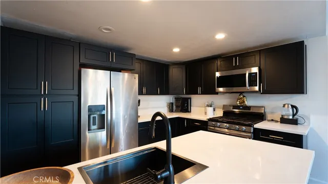 a kitchen with stainless steel appliances a refrigerator stove microwave and sink