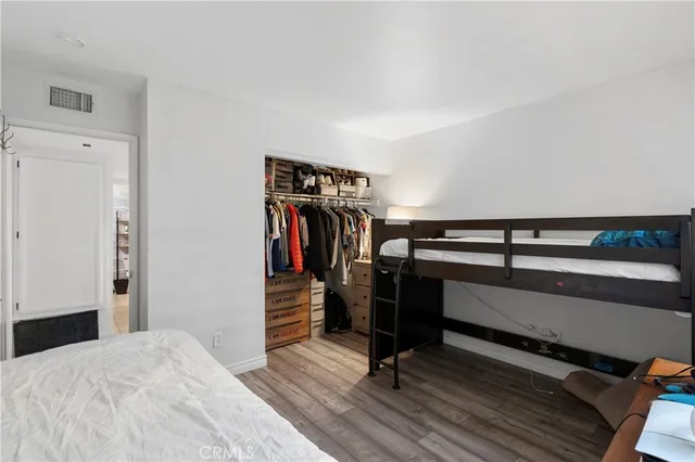 a bedroom with a bed and a wooden floor