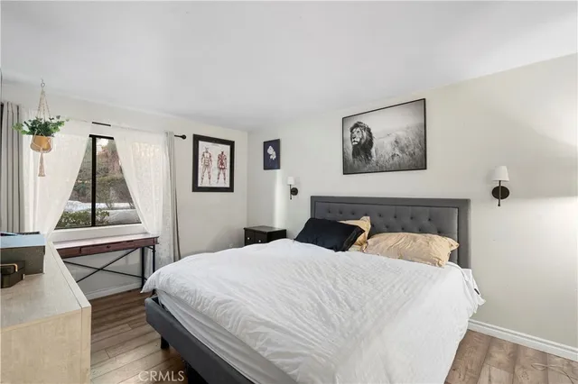 a bedroom with a bed and painting on the wall