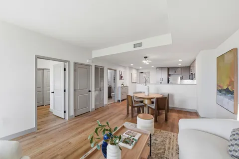a living room with furniture kitchen view and a dining table