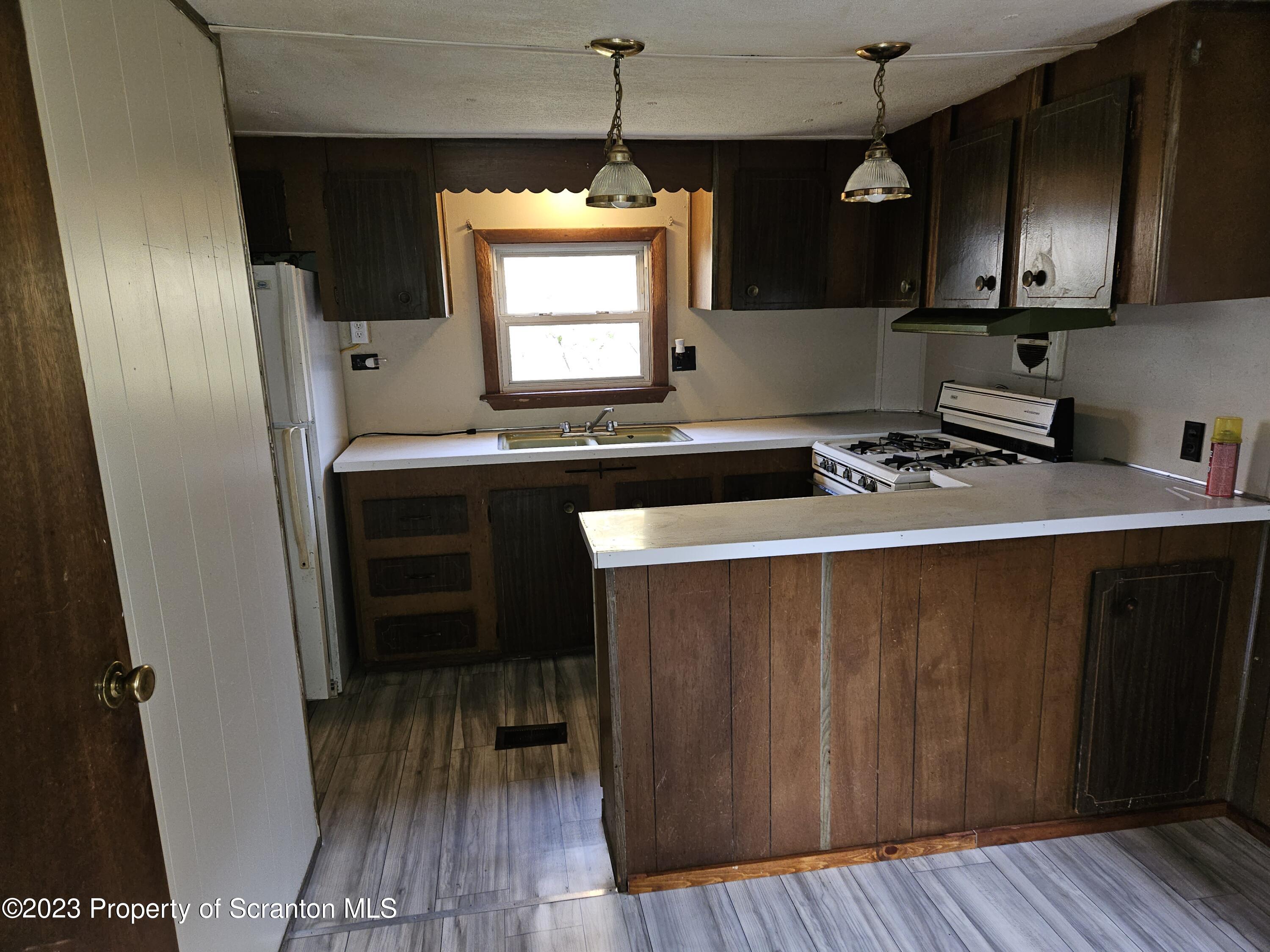 65 South Center Street Hop Bottom, PA 18824 - Photo 15 of 28 a kitchen with a sink a stove a refrigerator and cabinets