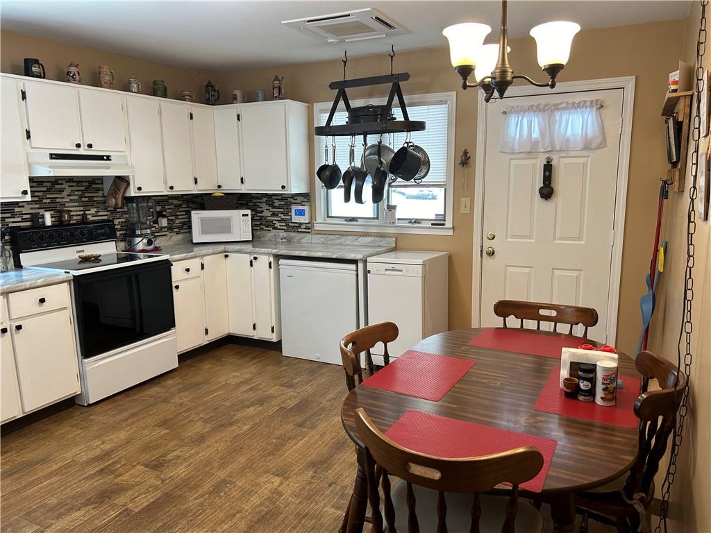 240 Martin Road Scottdale, PA 15683 - Photo 15 of 16 a kitchen with stainless steel appliances granite countertop a stove a sink dishwasher and white cabinets with wooden floor