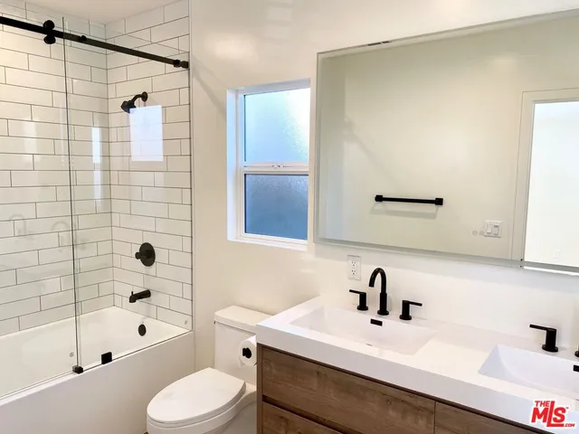 a bathroom with a sink mirror toilet and bathtub