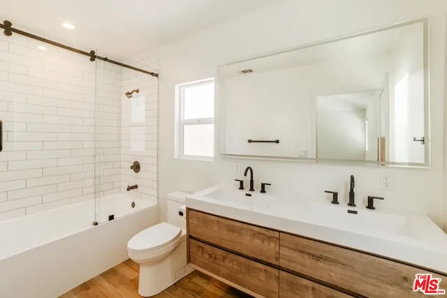 a bathroom with a sink toilet a mirror and shower