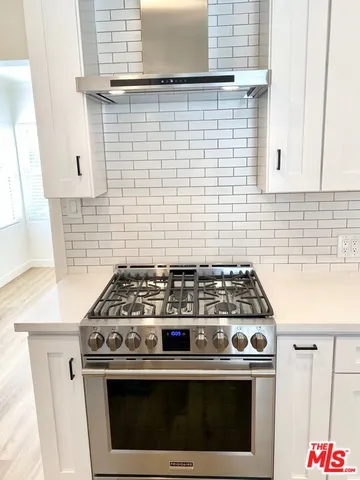 a stove top oven sitting inside of a kitchen