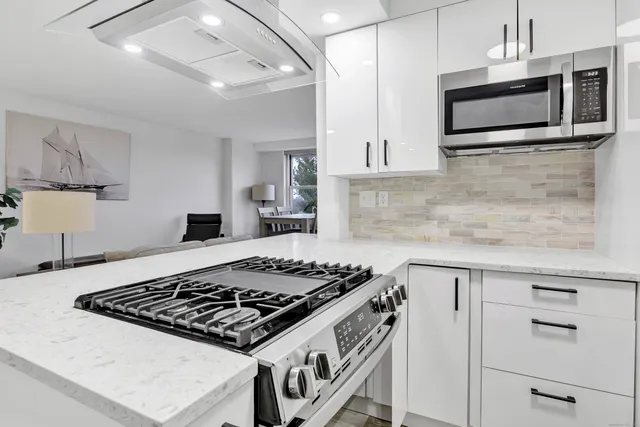 a kitchen with stainless steel appliances kitchen island a stove and a microwave