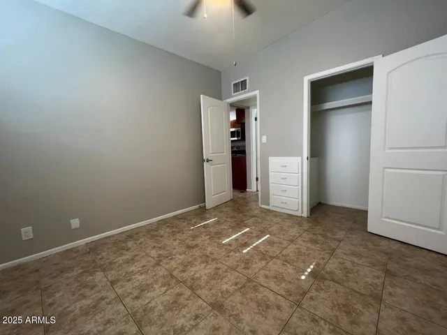 an empty room with closet and windows