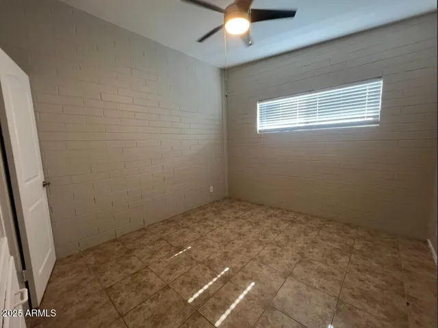 an empty room with a chandelier fan