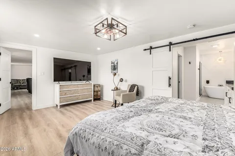 a spacious bedroom with a bed a television and a large window