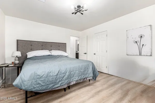 a bedroom with a bed and a painting on the wall