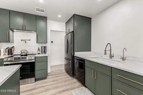 a kitchen with stainless steel appliances granite countertop a sink stove and refrigerator