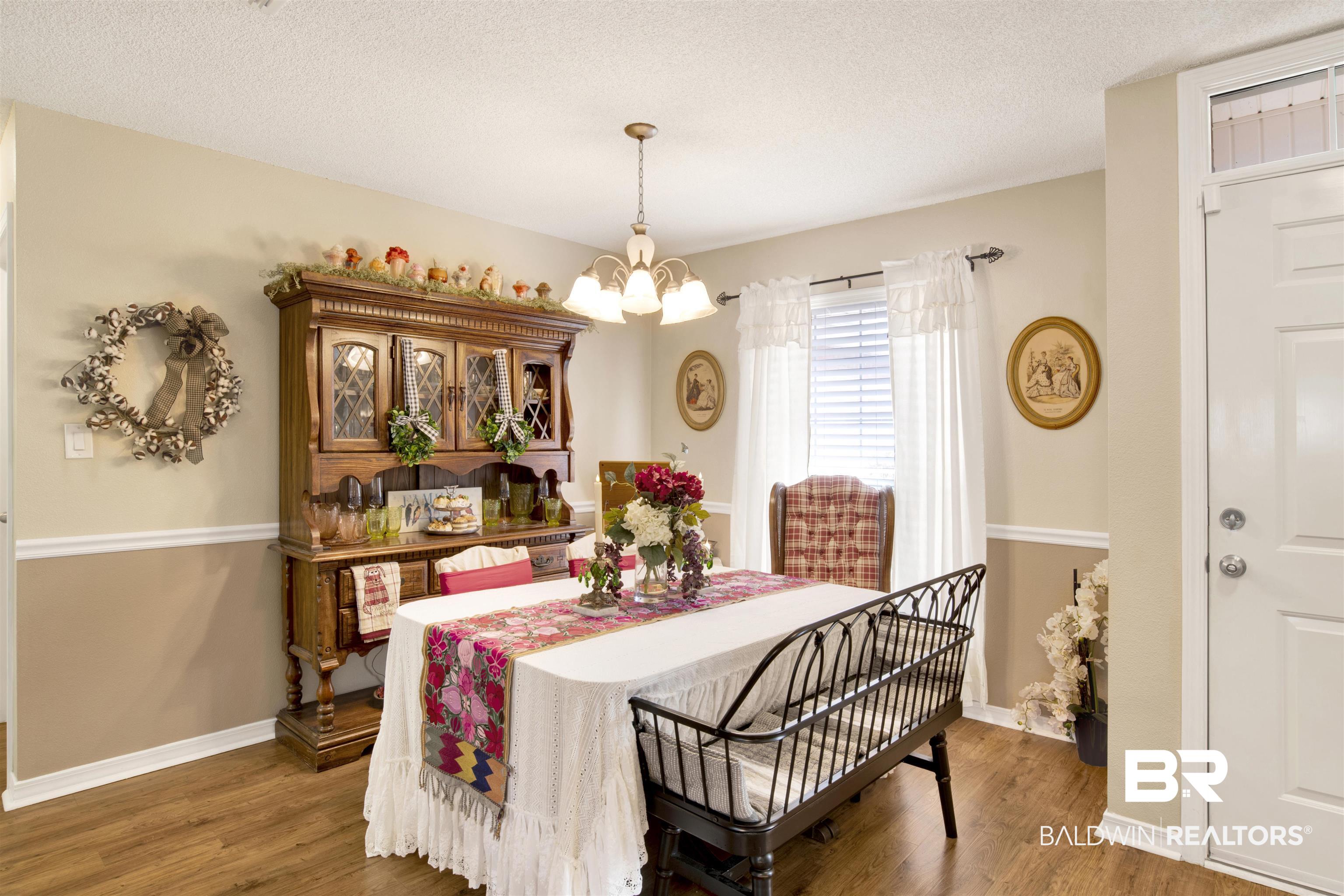 11697 Balsam Court Daphne, AL 36527 - Photo 21 of 31 Dining space featuring a textured ceiling, dark hardwood / wood-style floors, and a chandelier