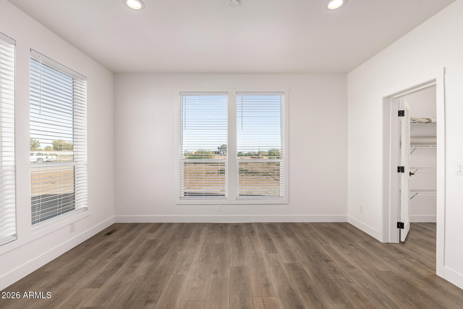23059 West Rancho Laredo Drive Wittmann, AZ 85361 - Photo 20 of 29 an empty room with wooden floor and windows