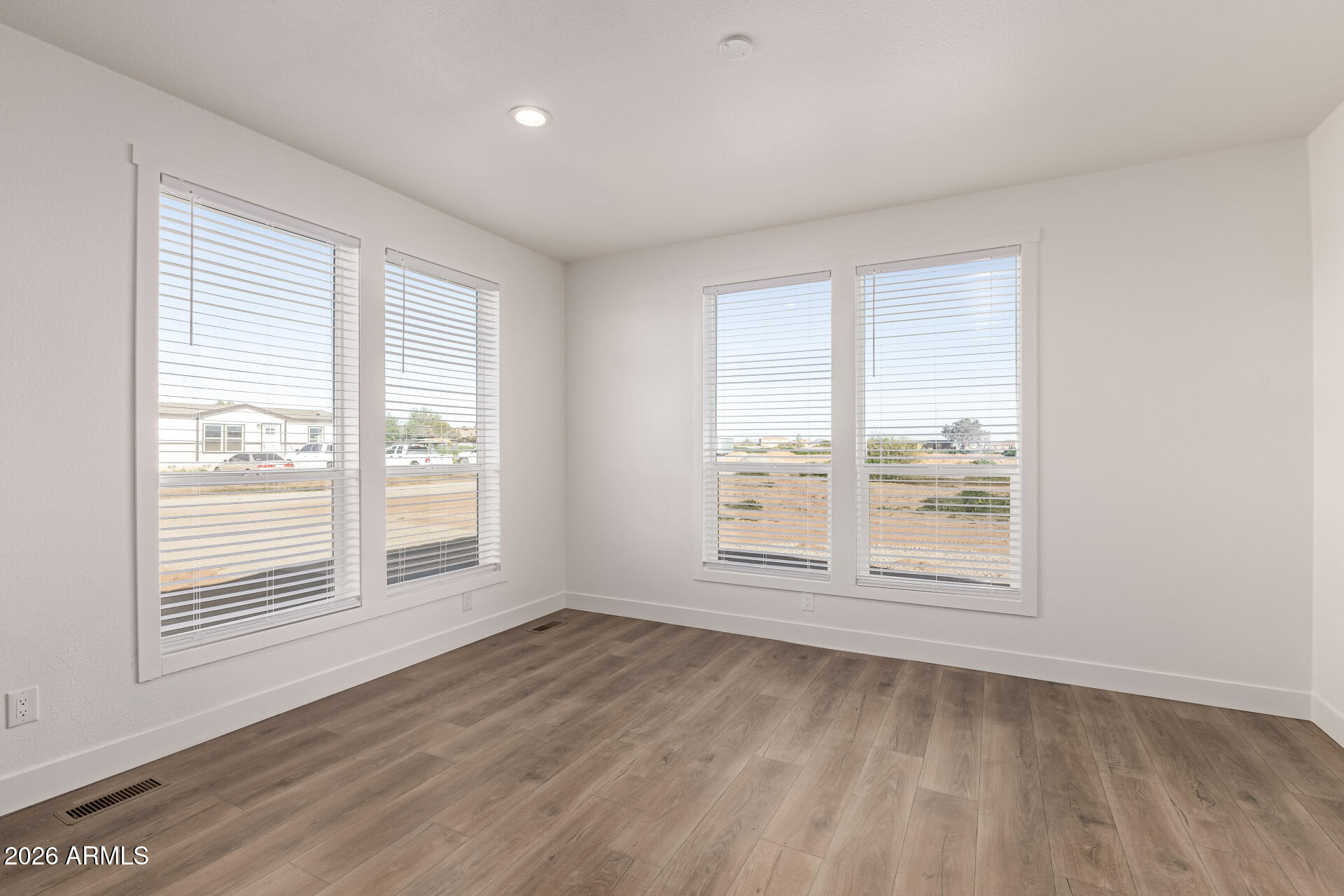 23059 West Rancho Laredo Drive Wittmann, AZ 85361 - Photo 21 of 29 an empty room with wooden floor and windows