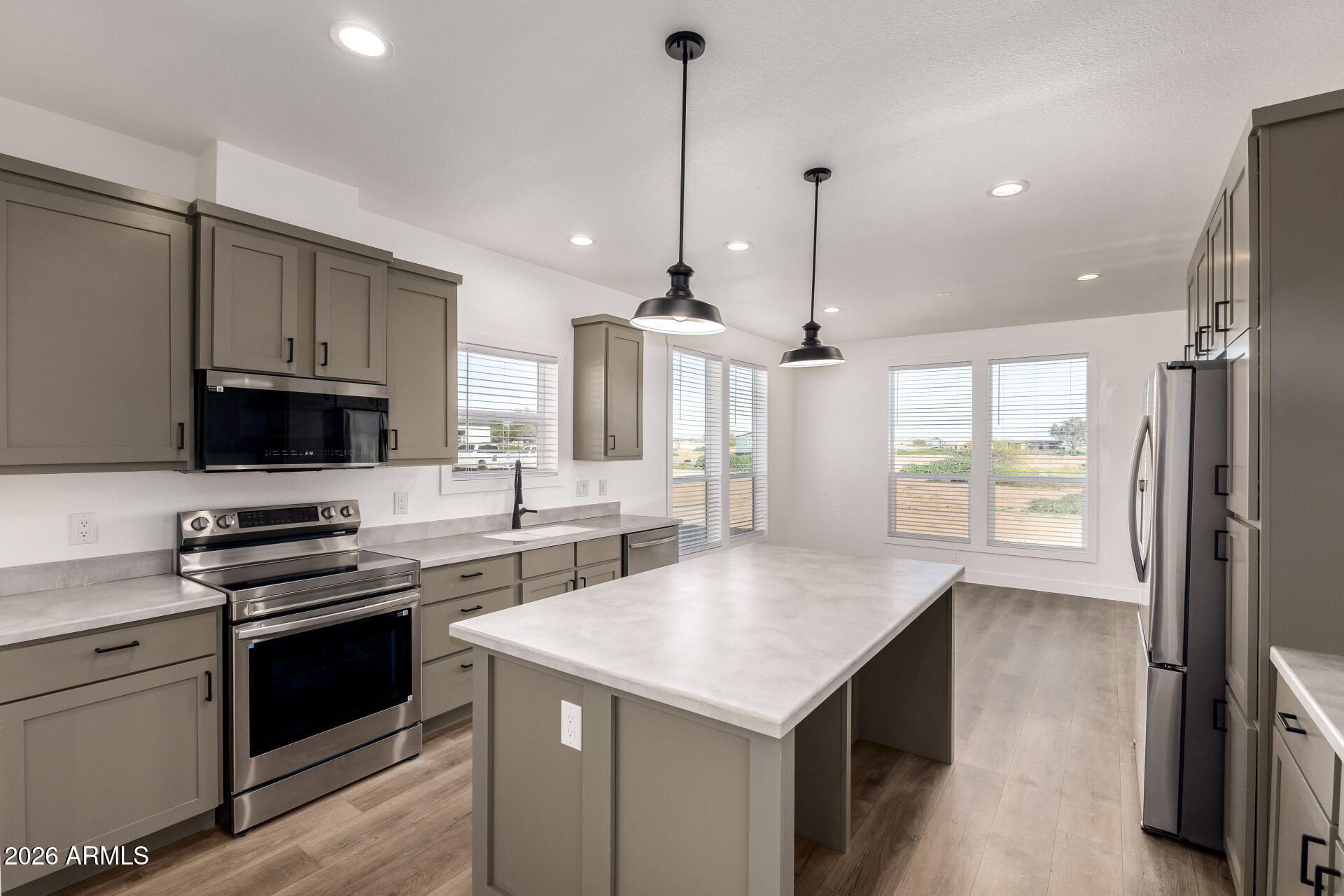 23059 West Rancho Laredo Drive Wittmann, AZ 85361 - Photo 4 of 29 a kitchen with a stove a sink and a refrigerator