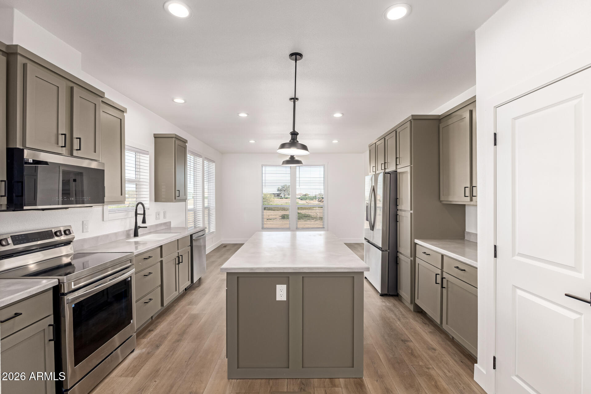23059 West Rancho Laredo Drive Wittmann, AZ 85361 - Photo 5 of 29 a large kitchen with stainless steel appliances granite countertop a stove refrigerator and cabinets