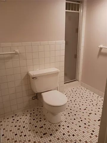 a bathroom with a toilet and a shower