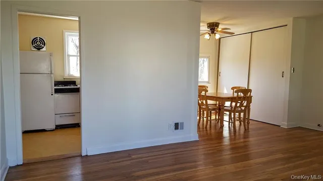 a view of a room with wooden floor table and chairs