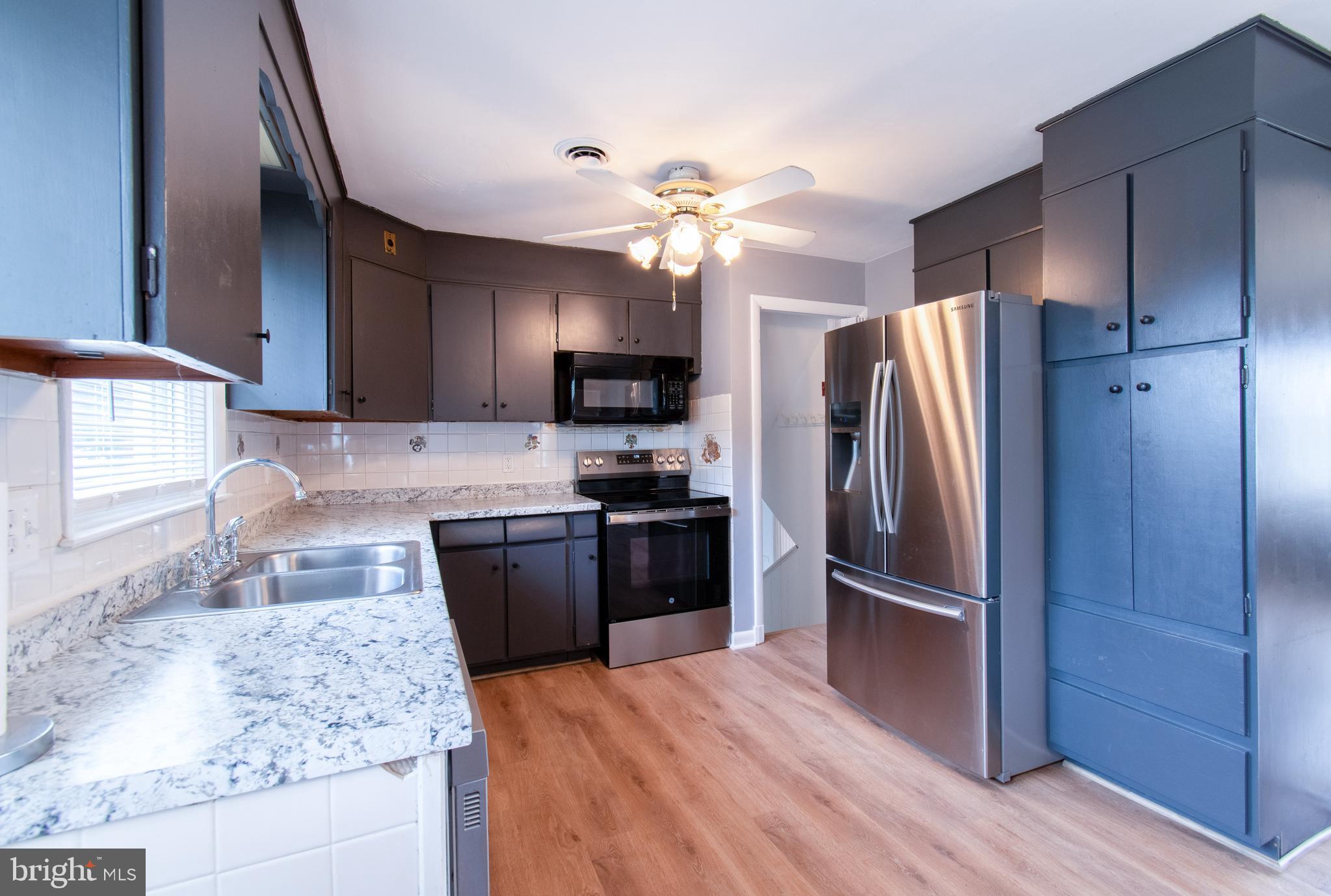 3911 Sunset Drive Hampstead, MD 21074 - Photo 11 of 38 a kitchen with a refrigerator sink and wooden cabinets