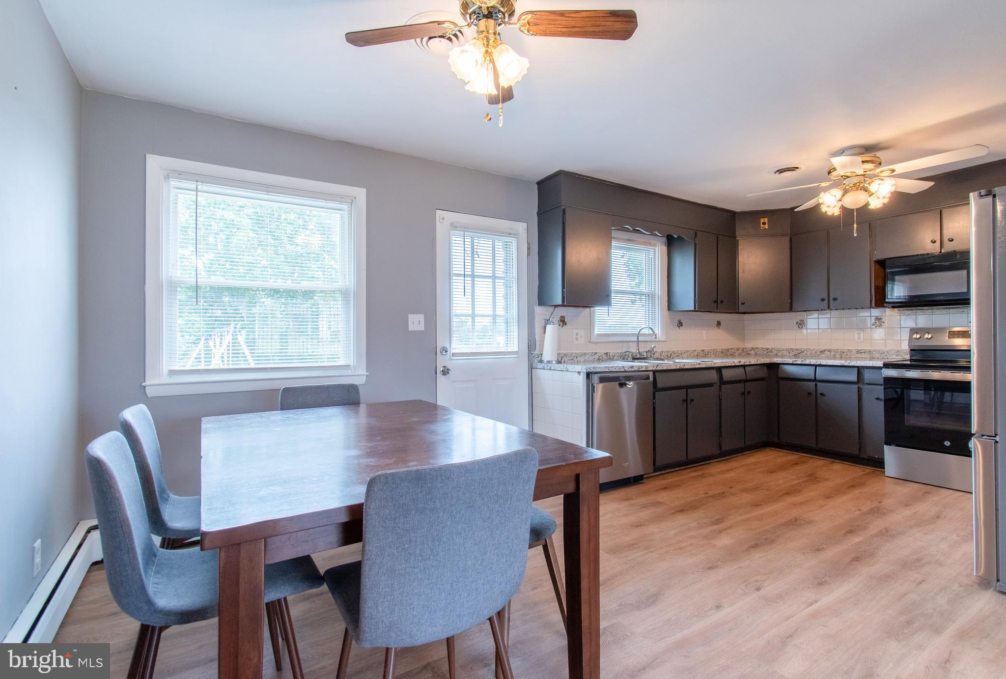3911 Sunset Drive Hampstead, MD 21074 - Photo 14 of 38 a kitchen with a stove a sink a dining table and chairs